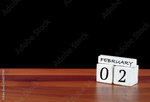 2 February calendar month. 2 days of the month. Reflected calendar on wooden floor with black background
