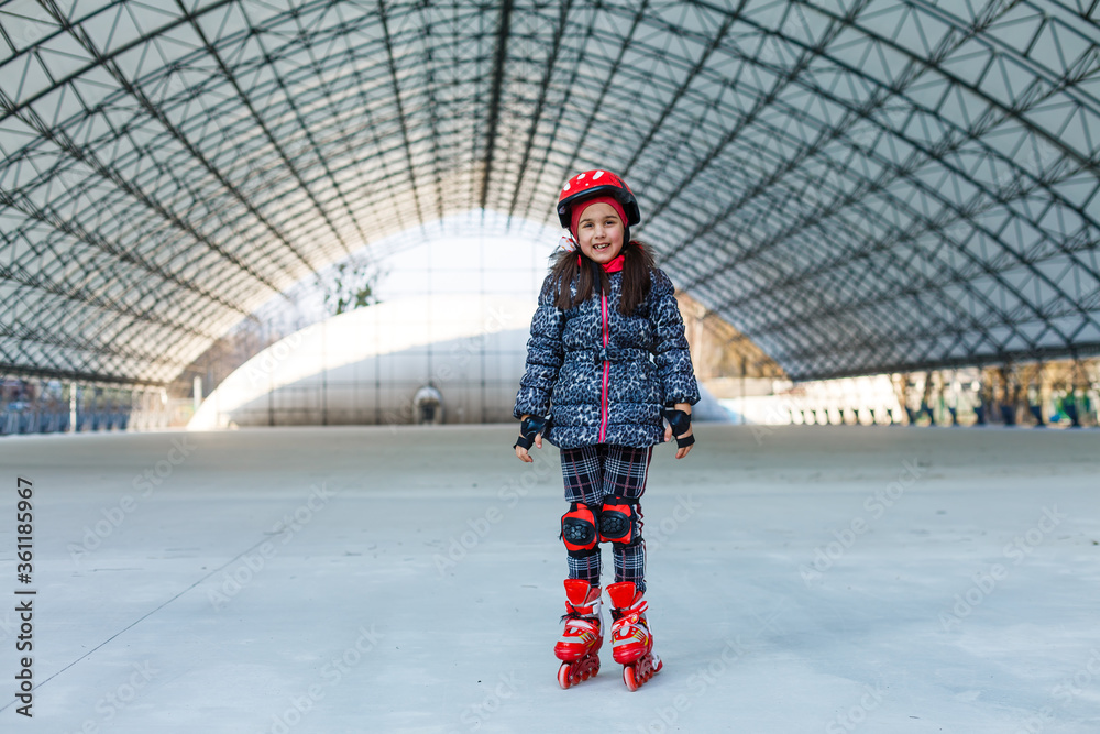 little girl rollerblading on roller rink