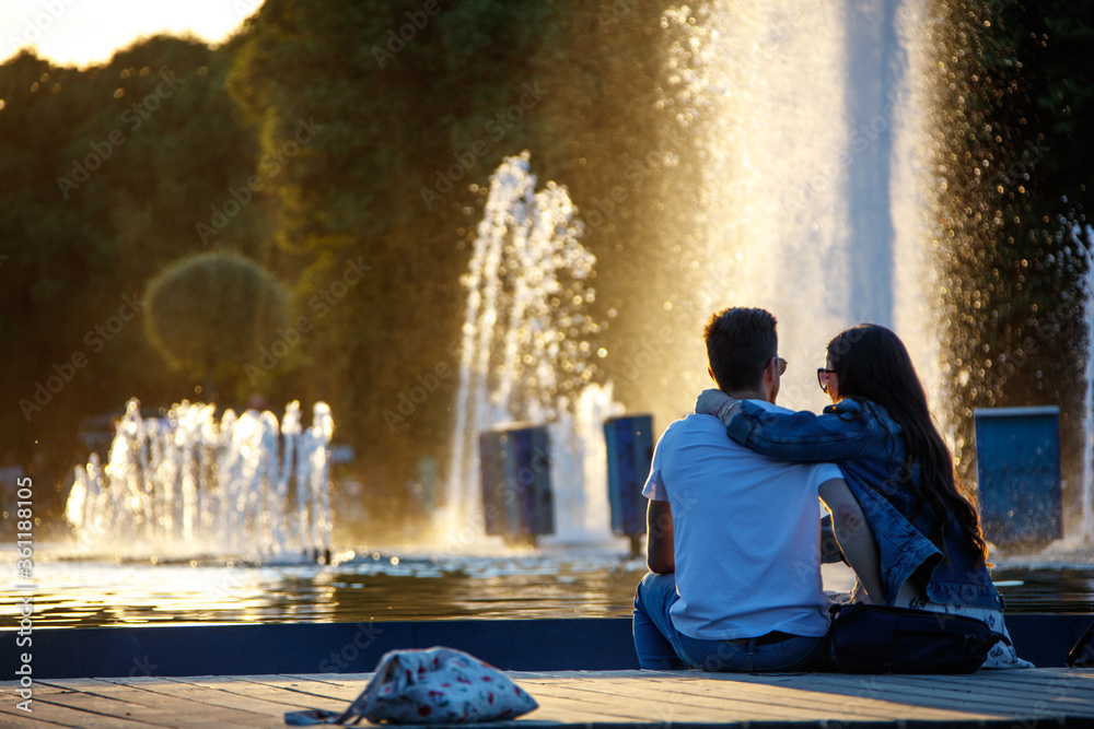 A young couple sitting by the fountain