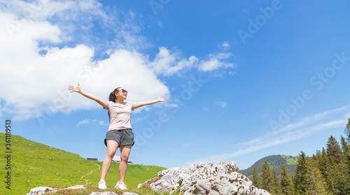 Beautiful Asian women with black hair and White skin wearing exercise clothes.she is standing Happy and smiling on the stone of the mountain, tourism of nature, Gantrischseeli at Switzerland,