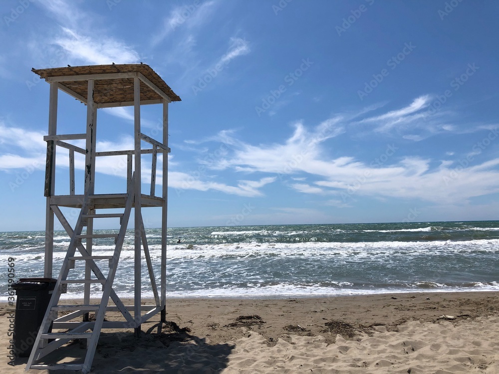 A white lifeguard tower on the beach .
