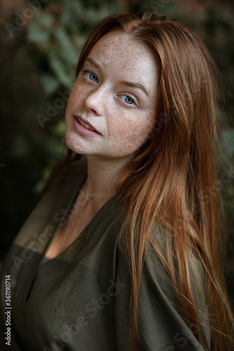 girl with red hair and freckles on a green background