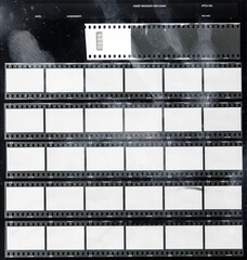 real macro photo of 35mm contact sheet with empty frames or cells on black background with grungy hand print marks.