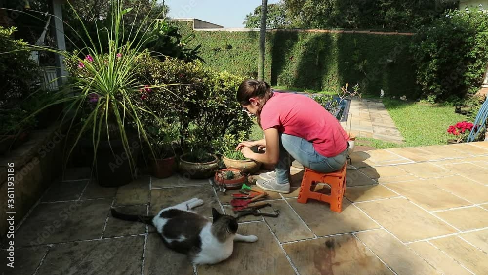 Cuidando do jardim da casa, tirando as ervas daninhas e adubando a terra.  Lazer e passa tempo.