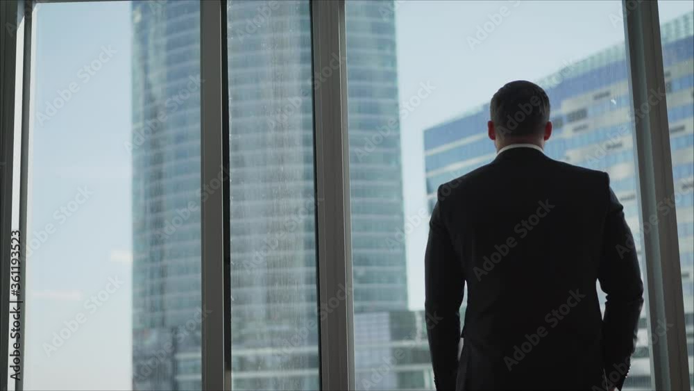 man looking on city through the window. Successful businessman in a business office. man looking on city through the window. Successful businessman in a business office.