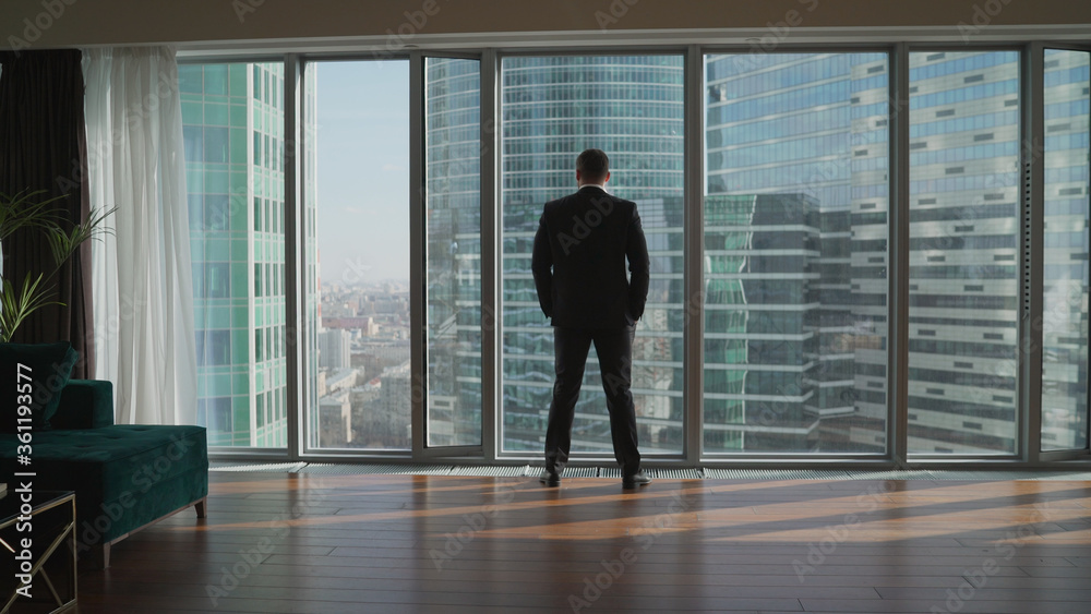 man looking on city through the window. Successful businessman in a business office. man looking on city through the window. Successful businessman in a business office.