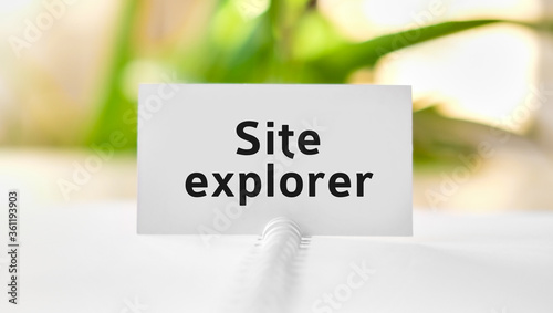 Web site explorer business seo concept text on a white notebook and green flowers photo
