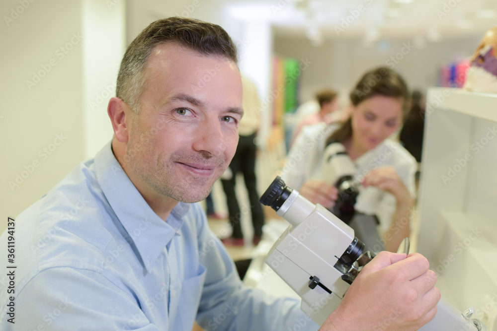 mature technician looking into microscope mature technician looking into microscope