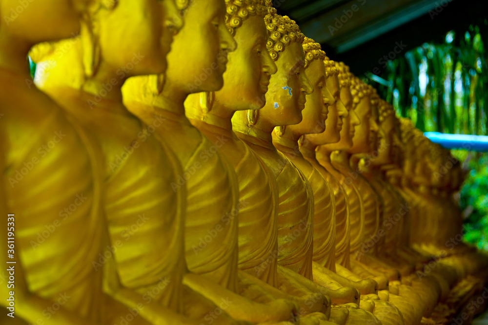 Obraz premium Golden Buddhist meditation statues at temple