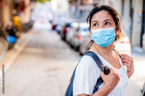 young tourist wearing face mask sightseing in european city. traveling and tourism industry during the corona virus pandemic and covid19 disease, affected by the global crisis