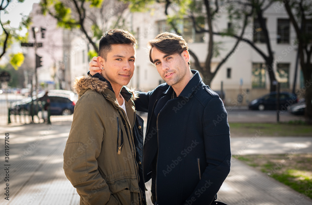 young men gay couple in the city looking at camera