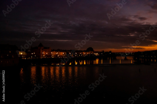 A view from Charles Bridge where sun sets over the river of Vltava. Reflection of lights and sunset makes the picture perfect.