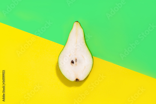 Creative layout made of pear on bright yellow and trendy green background.