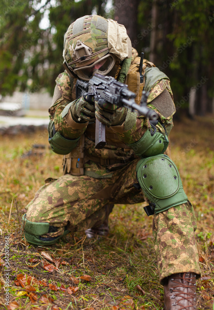 soldier with a gun in his hands aiming from the knee