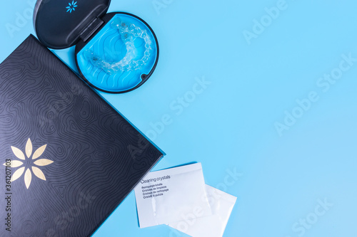Invisible transparent aligners invisalign blue package with a box, clear-plastic retainers and cleaning crystals. With copyspace for banners and websites photo