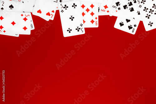 Deck of playing cards on red background table copy space