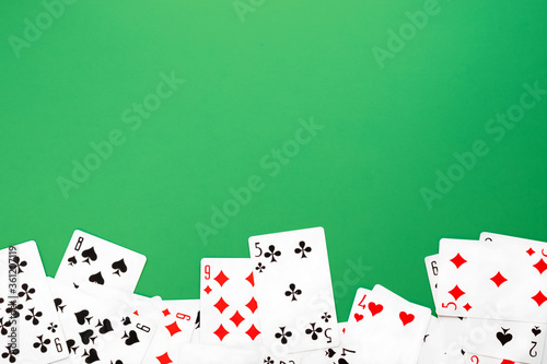 Deck of playing cards on green background table copy space