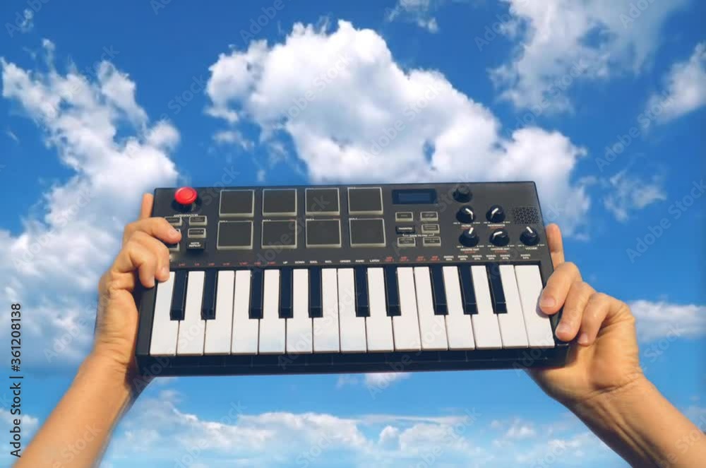 Hands holding music piano keyboard background sky 