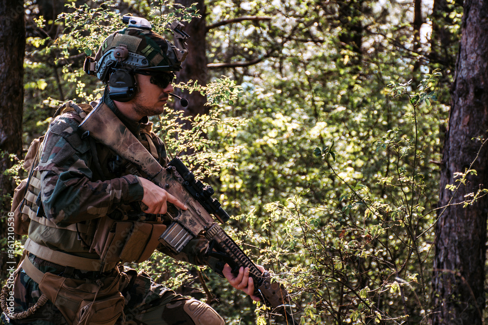 Soldier in a forest hiding in a foliage. Full equipment. soldier concept
Soldier in a forest hiding in a foliage. Full equipment. soldier concept