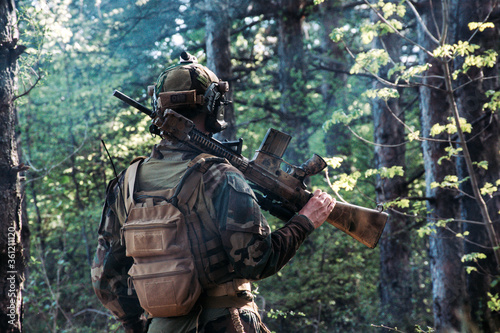  Soldier in a forest hiding in a foliage. Full equipment. soldier concept 
