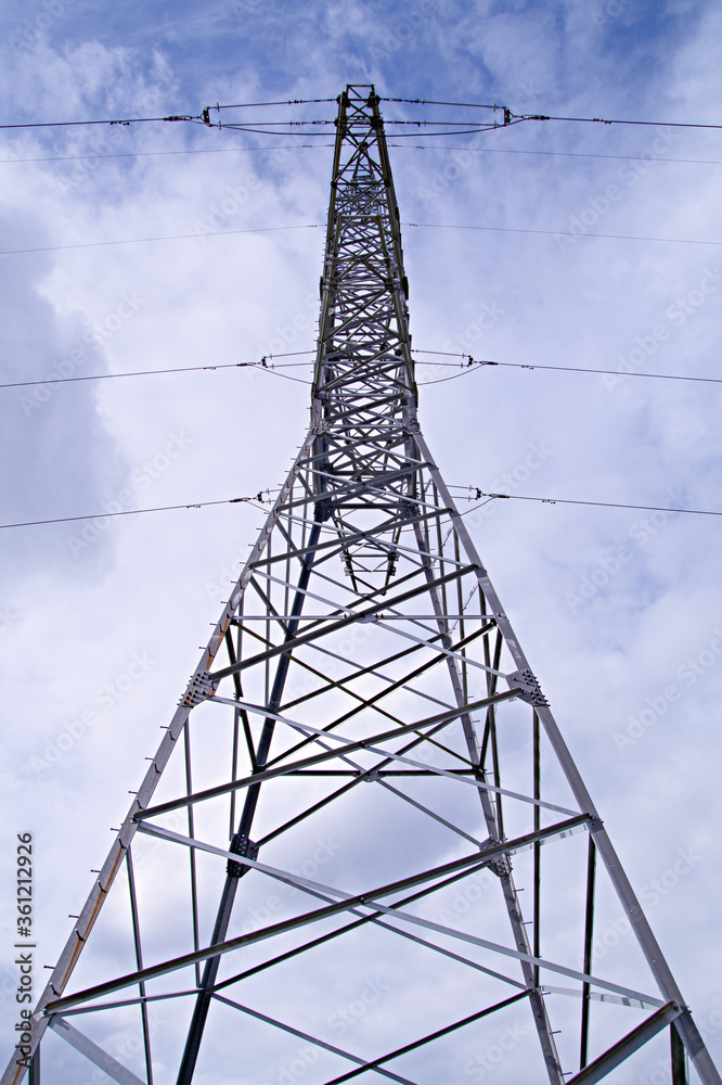 Power pole with wires against the blue sky. The correct form of metal construction Power pole with wires against the blue sky. The correct form of metal construction