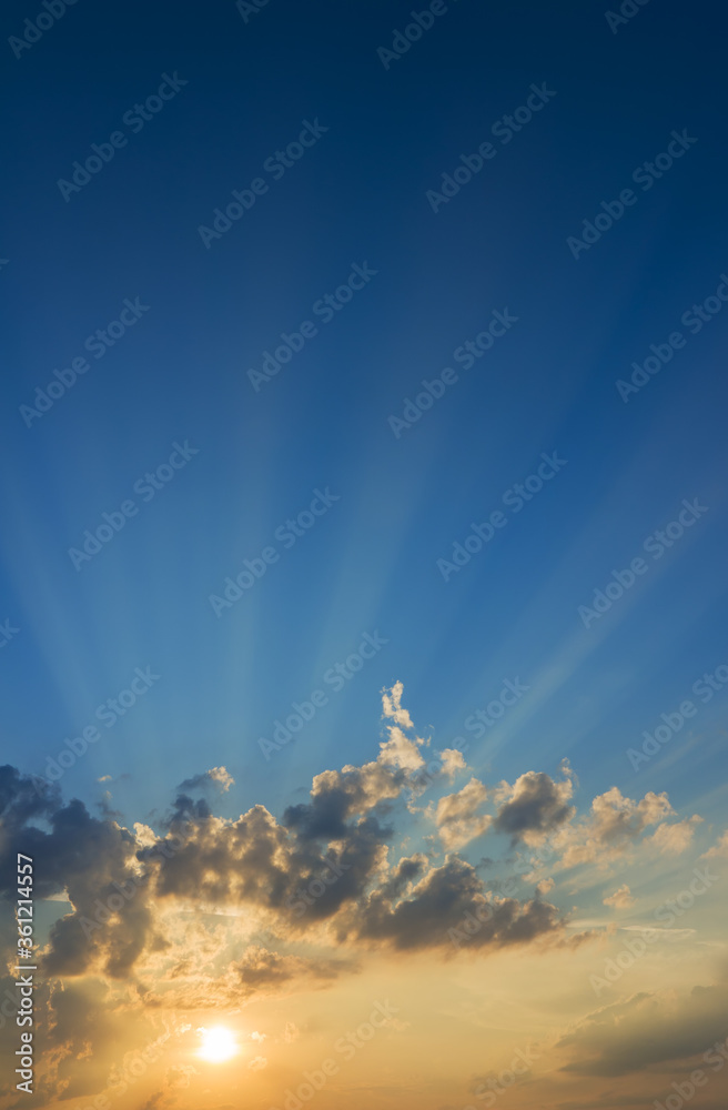 Beautiful sky with sun rays. Qualitative vertical photo of majestic colorful clouds in pastel tones.