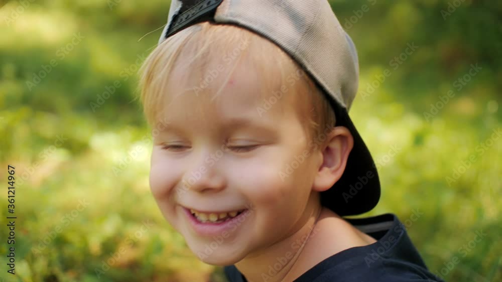 Close up portrait of cheerful cute laughing baby boy in cap posing at sunny summer day Close up portrait of cheerful cute laughing baby boy in cap posing at sunny summer day