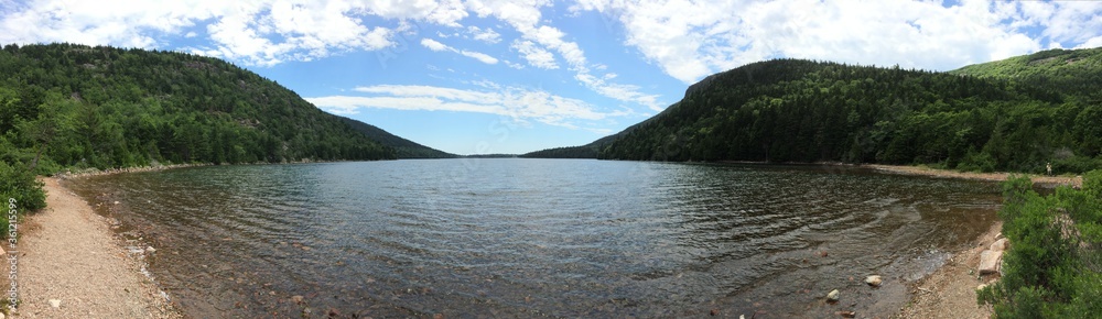 Panoramic image of lake with forests and hills surrounding it