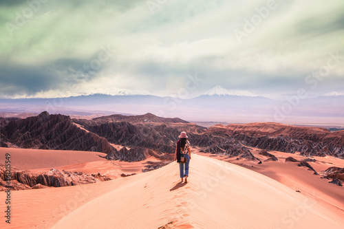 hike in the desert sand dunes overlooking red rock range and snow mountains in distance