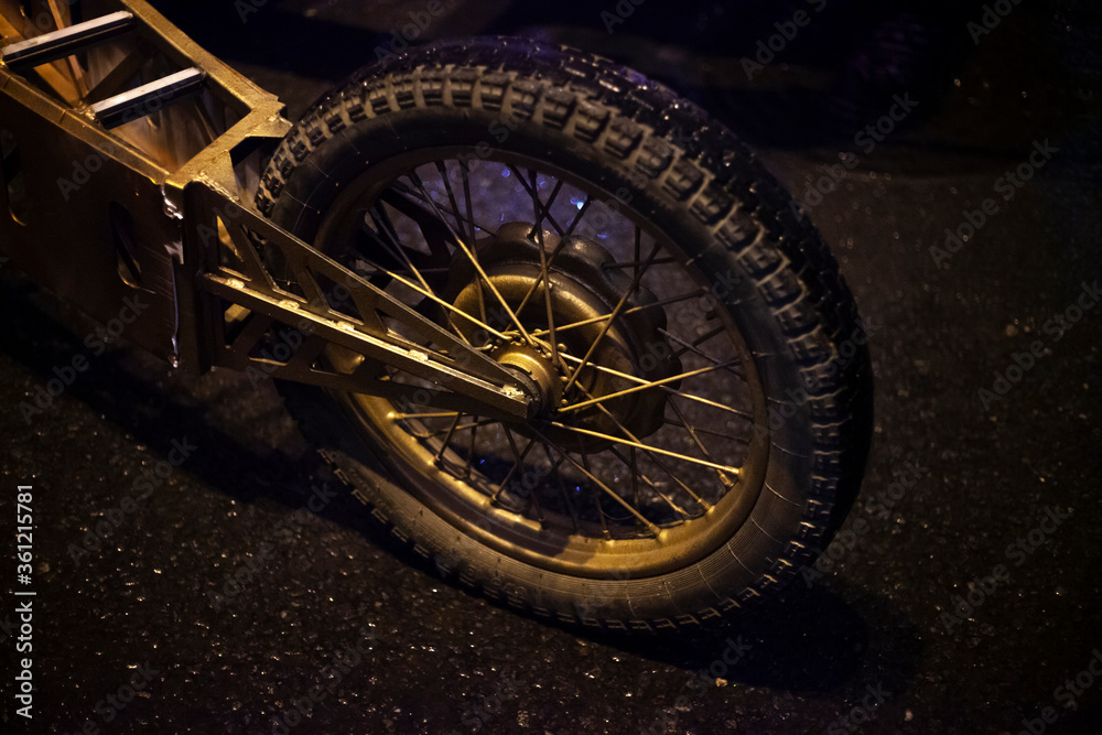 Moped wheel at night. The motorcycle wheel is on. Moped wheel at night. The motorcycle wheel is on.