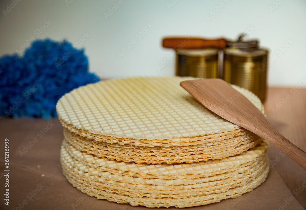 Obraz premium step by step, making a waffle cake, with condensed milk, and decorating with blue flowers