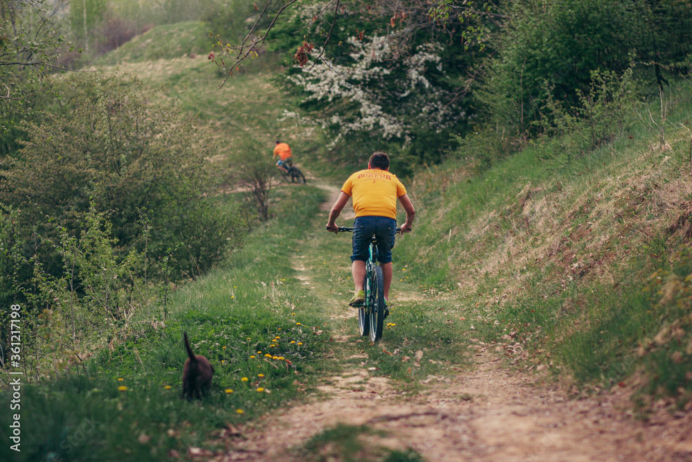 Obraz premium A man riding a bike down a dirt road