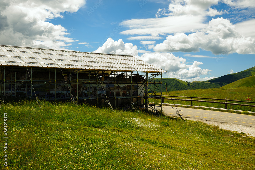 The small church of the Madonna della Cona, near Castelluccio di Norcia, surrounded by reinforcement structures to remedy earthquake damage. The small church of the Madonna della Cona, near Castelluccio di Norcia, surrounded by reinforcement structures to remedy earthquake damage.