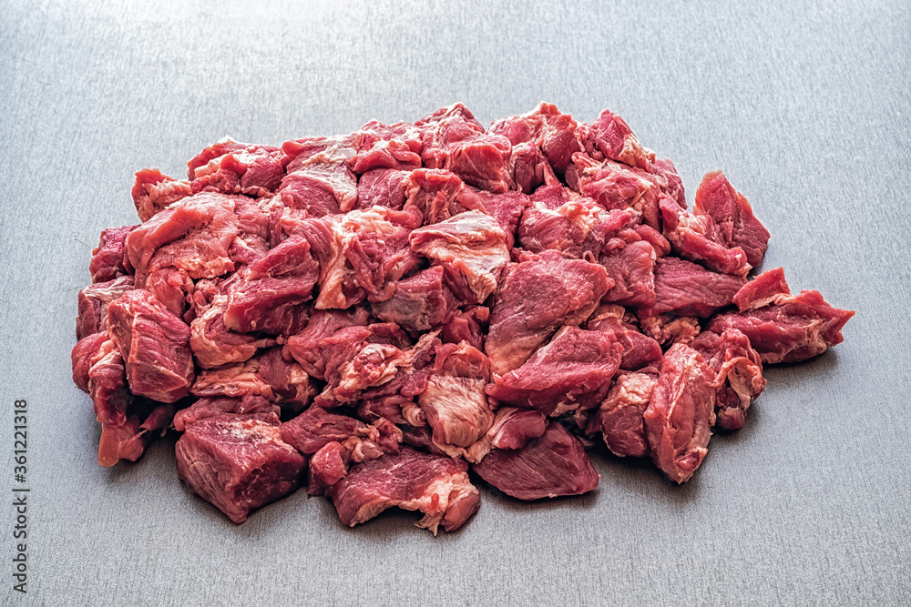 Obraz premium Pieces of raw meat on a grey table.