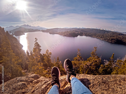 FIsheye photography of legs on a rock in the mountains and lake in the background
