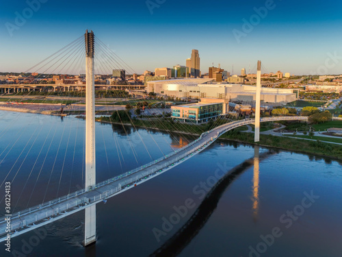 Canvastavla Bob Kerry Pedestrian Bridge spans the Missouri river with the Omaha Nebraska skyline in the background