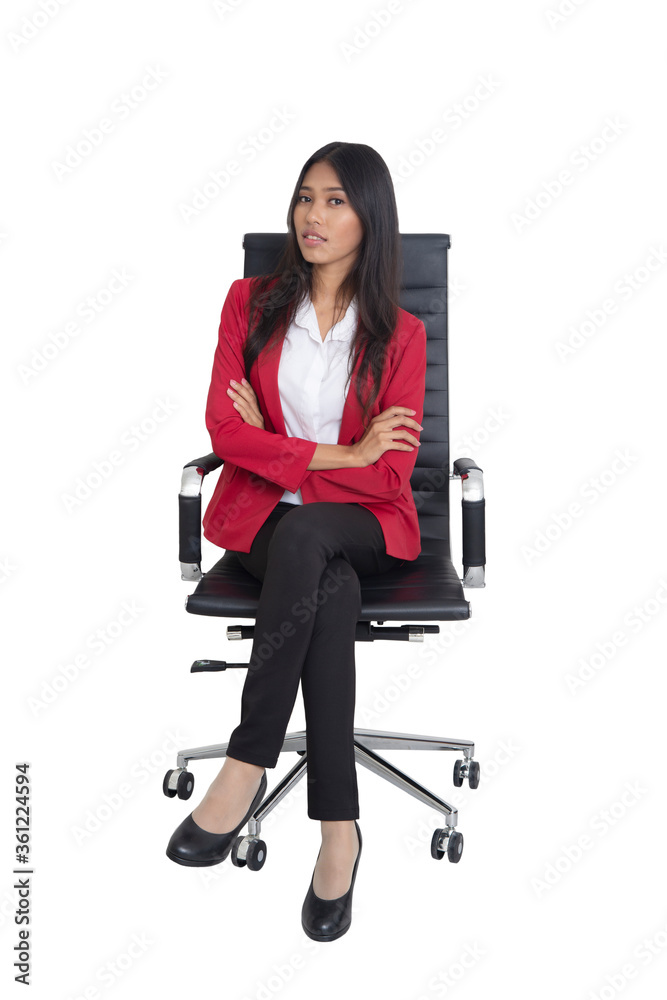 Businesswoman in red suit cross her arms while sitting in black armchair.. Businesswoman in red suit cross her arms while sitting in black armchair..