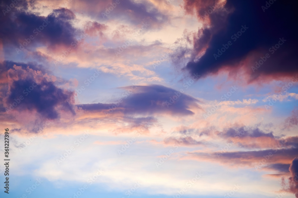 Lush cloudy sky in the sunrise lights. Vivid colors of nature and atmosphere. Sunlights through clouds Lush cloudy sky in the sunrise lights. Vivid colors of nature and atmosphere. Sunlights through clouds