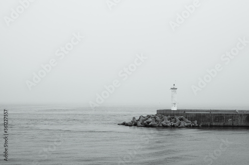 Mini Lighthouse on the coast. small lighthouse on the pier in black and white