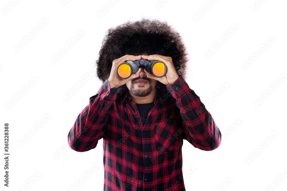 Young Afro man looking through binocular on studio Young Afro man looking through binocular on studio
