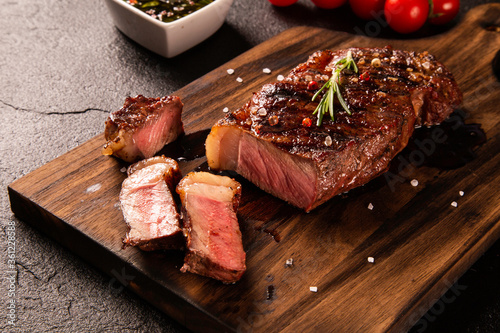 Fresh grilled meat. Grilled beef steak medium rare on wooden board. Picanha. Top view. photo