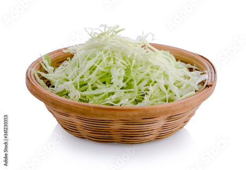 Green sliced cabbage in wooden basket isolated on white background