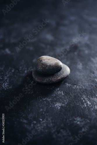 meditation concept, stacked pebbles on dark background with minimalist composition