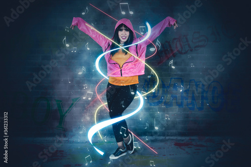 Hip-hop dancer with graffiti wall background © Creativa Images