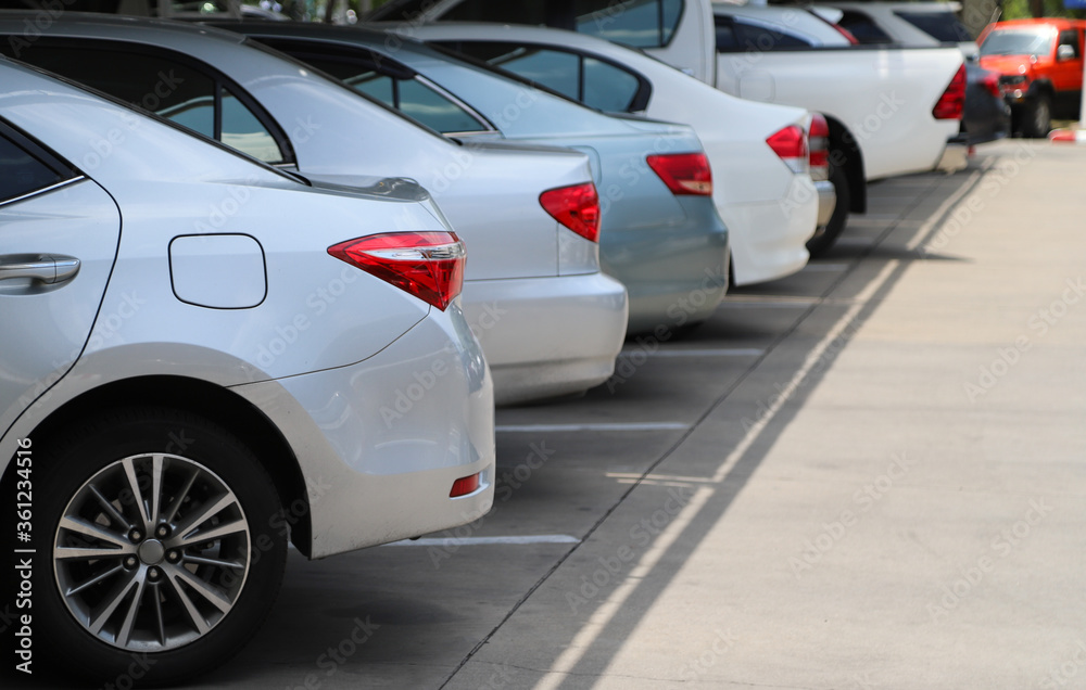 Closeup of rear, back side of bronze car with  other cars parking in indoor parking area in bright sunny day.
