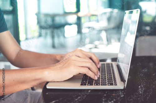 Woman hand using laptop to work study on work desk with clean nature background background. Business, financial, trade stock maket and social network.