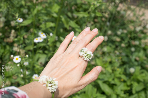 Female hand in a four-leaf clover flowers ring. © bong
