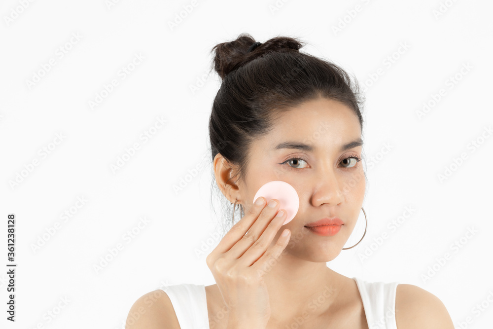 Pretty beauty young Asian woman cleaning her face with cotton pad over white isolated background. Healthy skin and cosmetics concept. Pretty beauty young Asian woman cleaning her face with cotton pad over white isolated background. Healthy skin and cosmetics concept.
