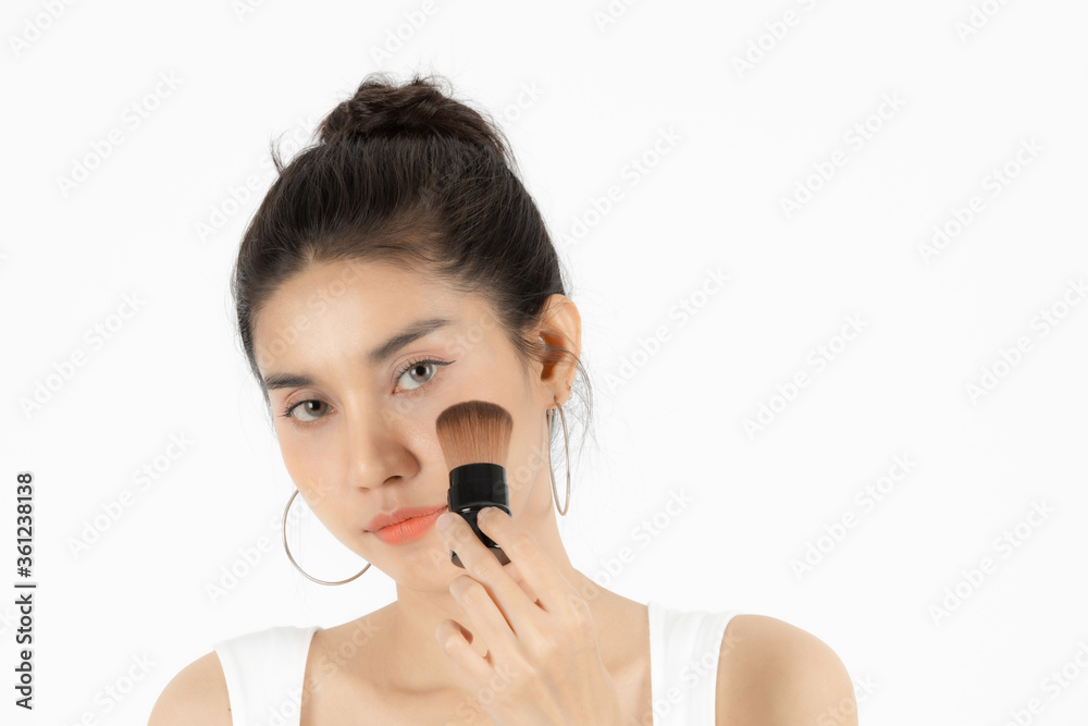 Healthy and cosmetics concept. Beauty face of young Asian woman applying make up with brush over white isolated background. Healthy and cosmetics concept. Beauty face of young Asian woman applying make up with brush over white isolated background.