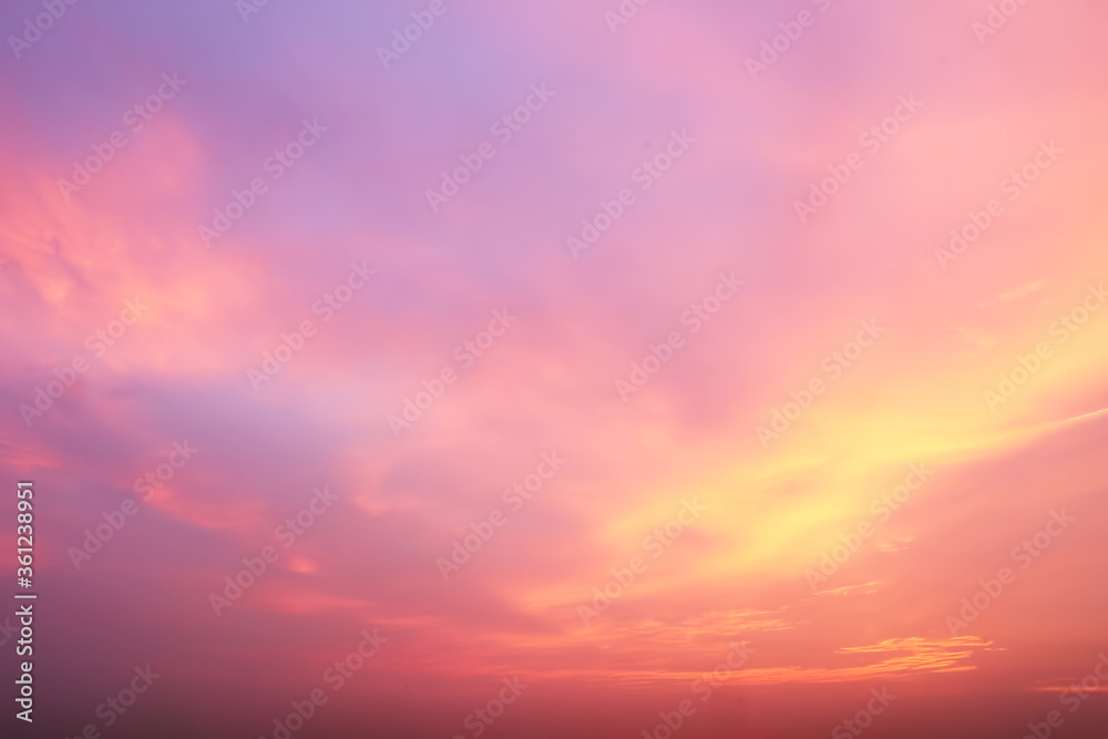 Dramatic atmosphere panorama view of fantasy twilight sky and soft colorful clouds with vivid shiny golden sunlight.